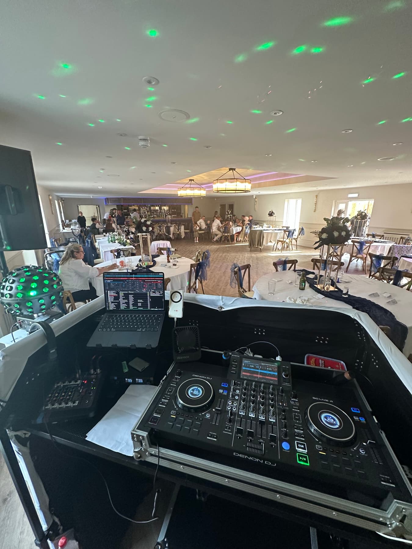 A wedding reception viewed from behind Jordan’s DJ decks