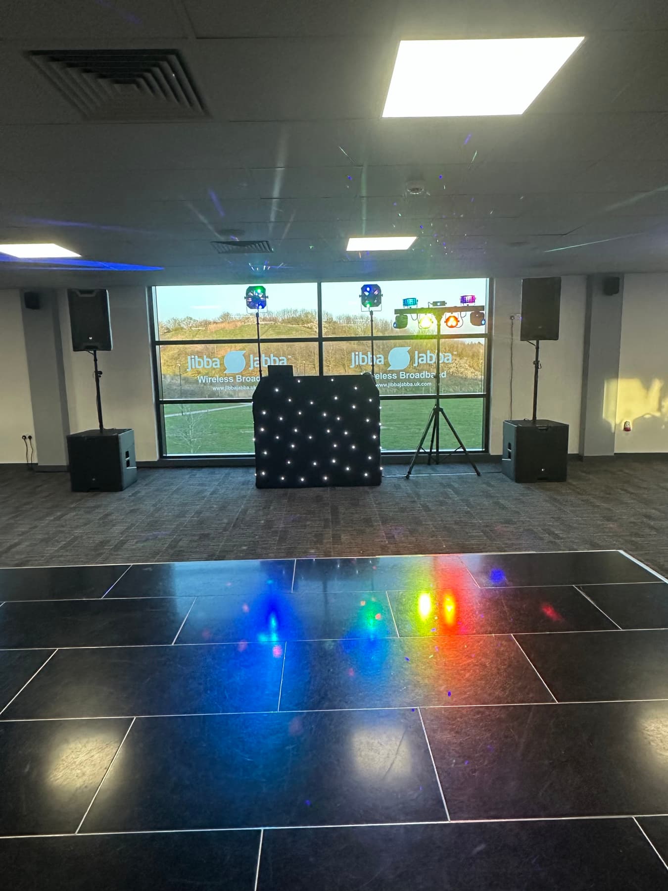DJ booth and colourful lighting overlooking a dance floor